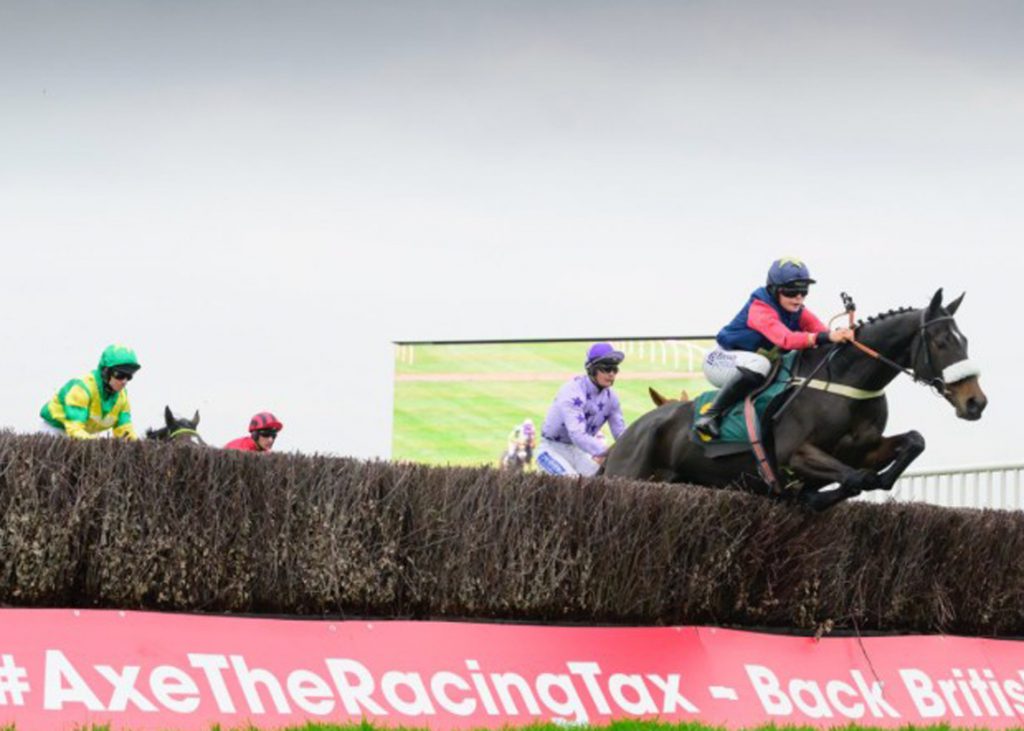A horse hurdles a hurdle