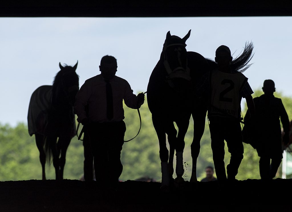 Grooms in silhouette at Monmouth Park